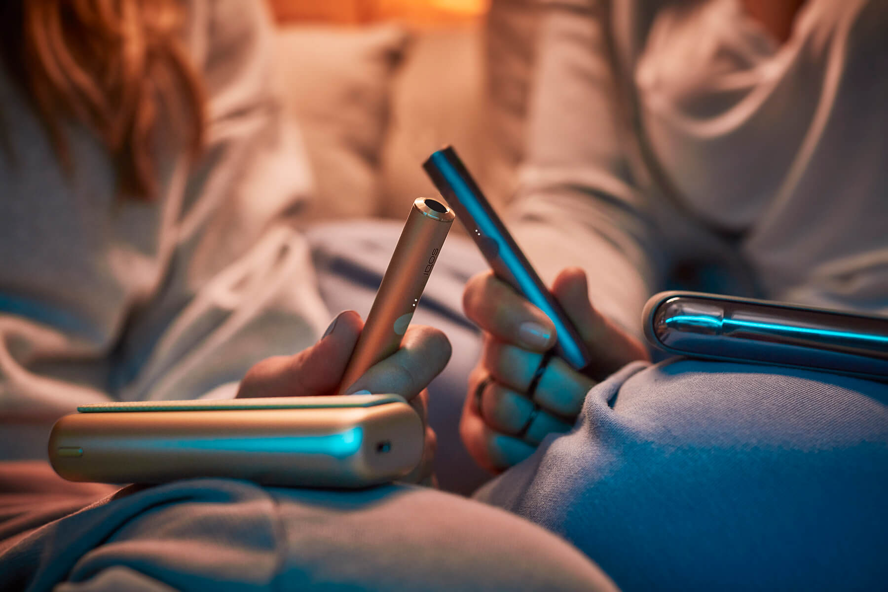 Dos usuarios de IQOS con dispositivos en la mano